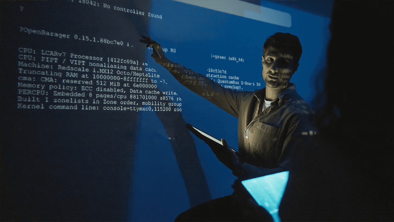 An engineer pointing at system code displayed on a large screen, illustrating AI engineering and enterprise system design.